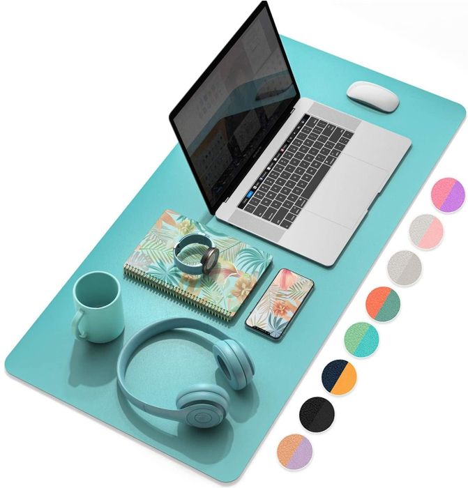 The turquoise desk pad with a laptop and accessories arranged on top of it.
