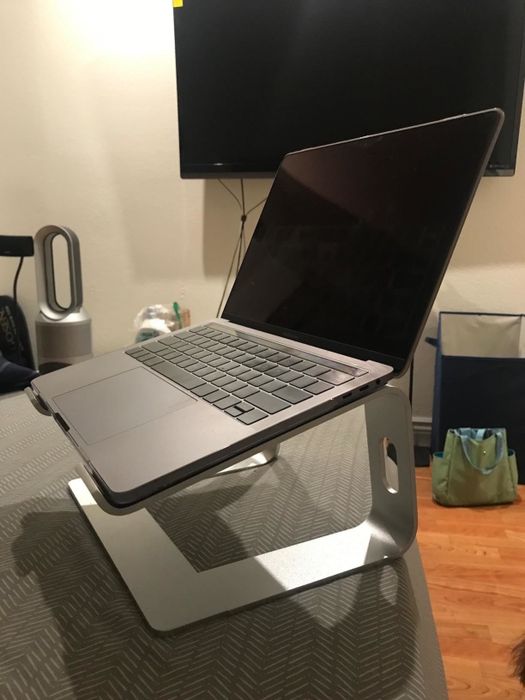 the laptop placed on the silver riser