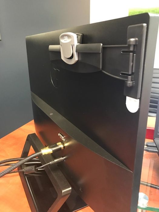 A reviewer photo showing the clip folded back behind the monitor.