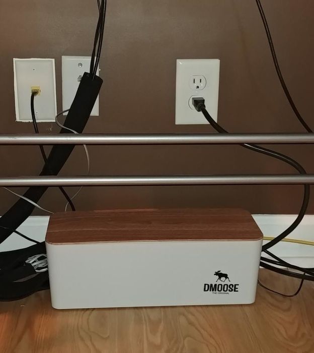 The same reviewer now displaying all the cords neatly organized in a cable box.