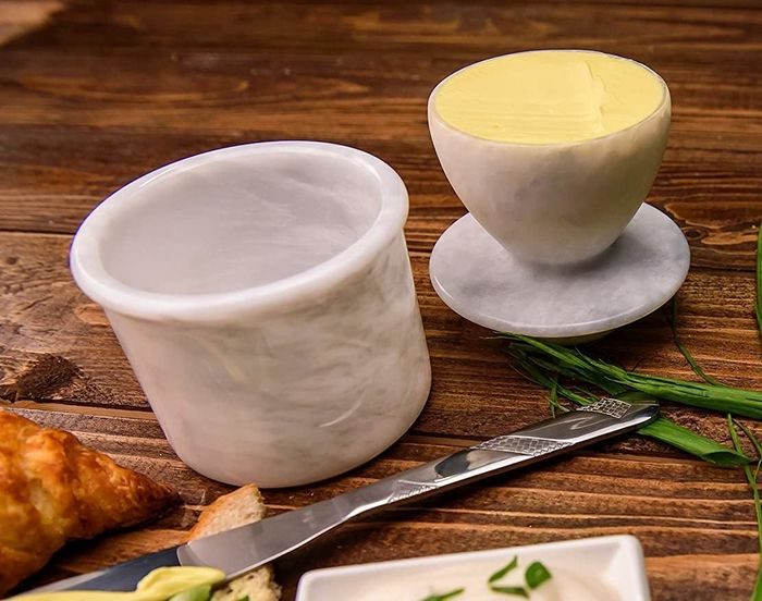 A marble butter keeper, elegantly designed with butter inside, keeping it at the ideal spreadable consistency.