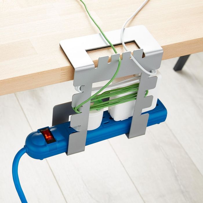 A metal organizer with five compartments and multiple cable wrap points to keep cords tidy and in place.