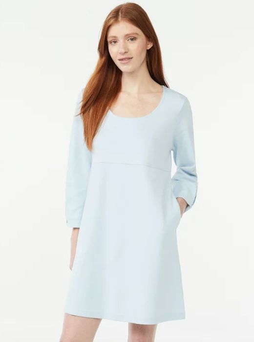 The model is sporting a u-neck long-sleeve mini dress in a soothing baby blue color.