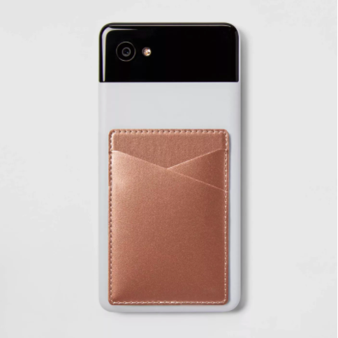 The rose gold stick-on wallet attached to the back of a phone case.