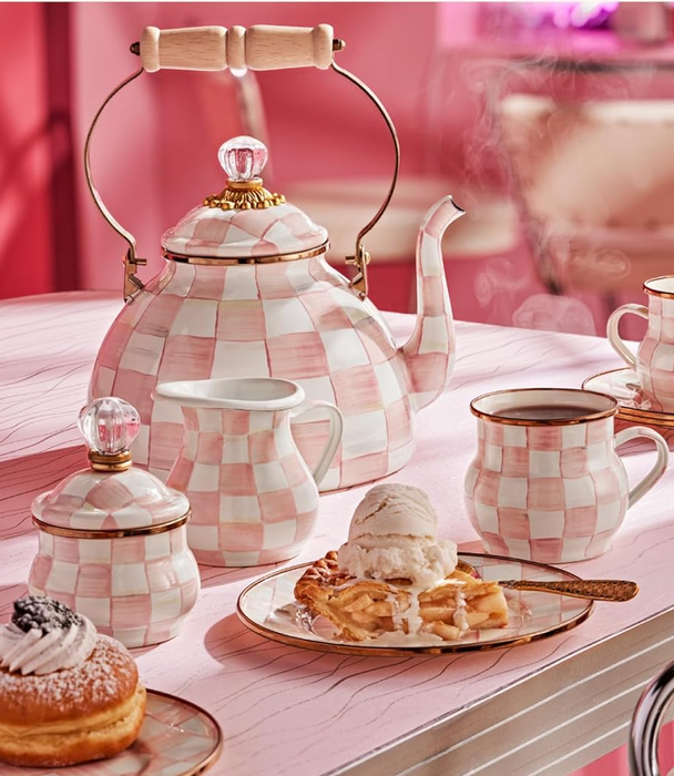 A pink rosy checkered kettle paired with matching cups, perfect for a charming tea time.