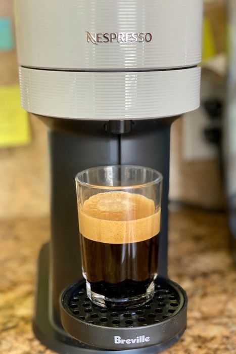 The same reviewer showing their Nespresso machine pouring a fresh espresso