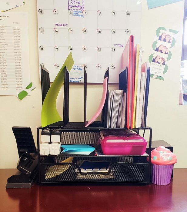 A reviewer’s desk organizer filled with various desk supplies inside.