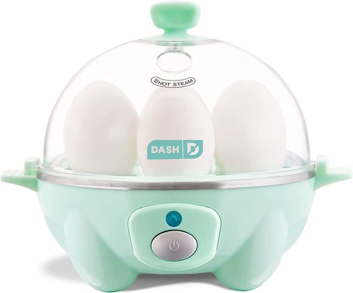 The egg cooker surrounded by fresh eggs.