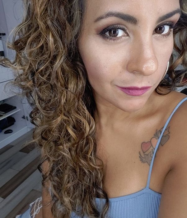 A customer proudly displays their soft, shiny curly hair after using the Moroccan Argan Oil Shampoo and Conditioner.