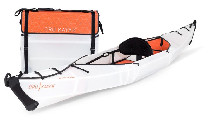 A full-size kayak next to its compact, folded version with a convenient carrying strap.