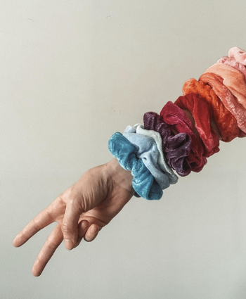 The reviewer’s hand flashing the peace sign, with several scrunchies adorning their arm