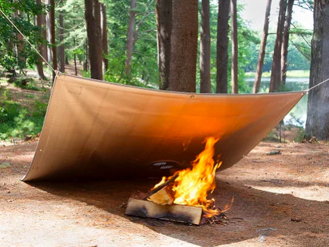A protective cover placed over a campfire, resembling a blanket.