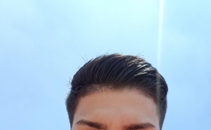A reviewer showing their hair styled with the clay pomade