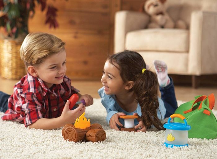 Children happily playing with camping-themed toys, engaging in outdoor adventures indoors.