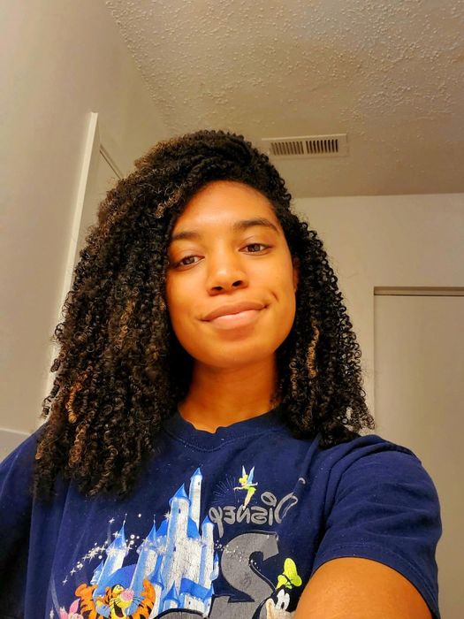 A reviewer showcasing their hair after applying Eden BodyWorks leave-in conditioner