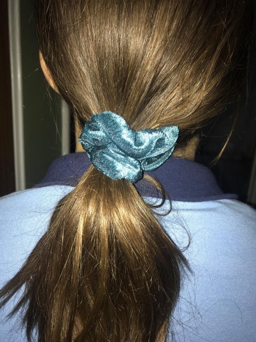 A picture of the blue velvet scrunchie in the reviewer's hair