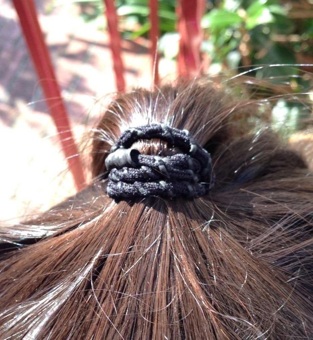 A reviewer's hair showcasing a ponytail held firmly in place by one of these elastics.