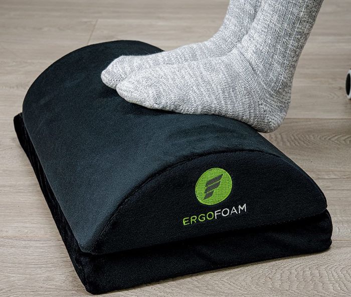 A model relaxing with their feet placed on the rounded side of the foam footrest for added comfort.
