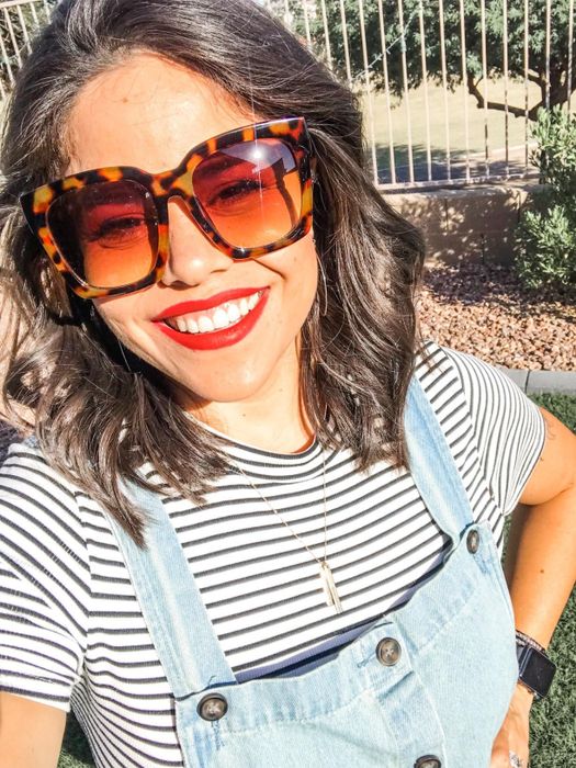 A reviewer showcasing the tortoise shell sunglasses