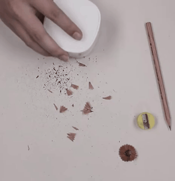 A gif of the desktop vacuum efficiently sucking up pencil shavings.