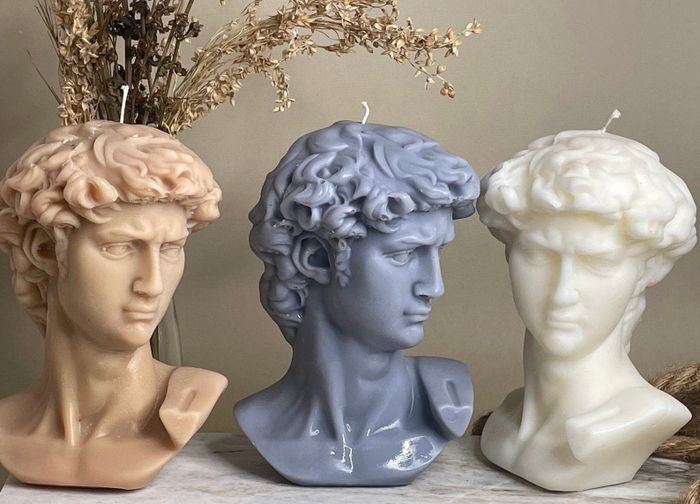 Three David bust candles in various colors displayed together.