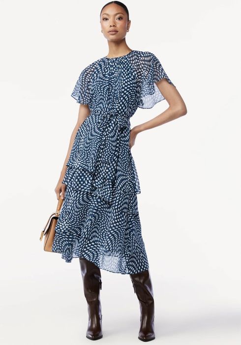 The dress features a white and blue polka dot pattern, adding a playful and retro touch.