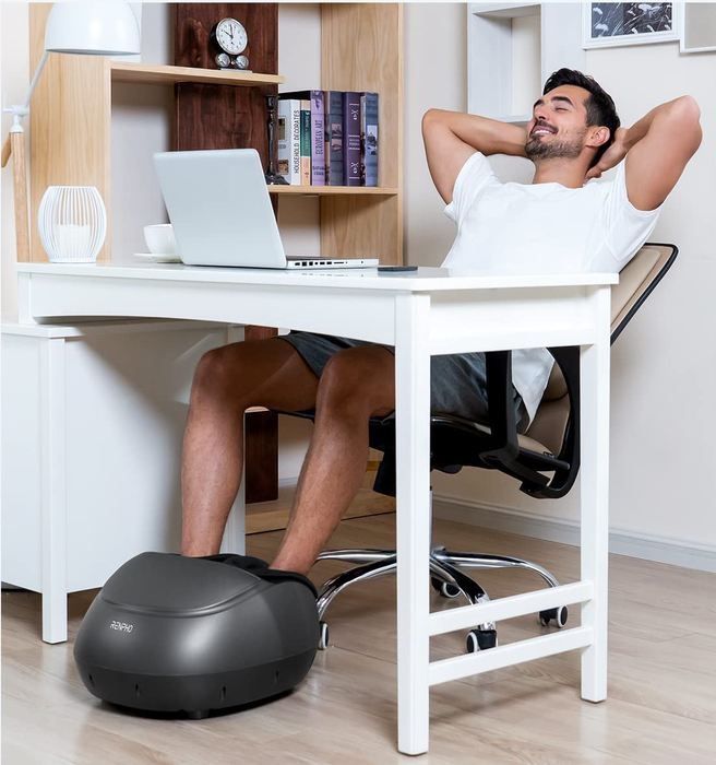 A model enjoying the relaxing benefits of the foot massager while sitting comfortably at a desk.
