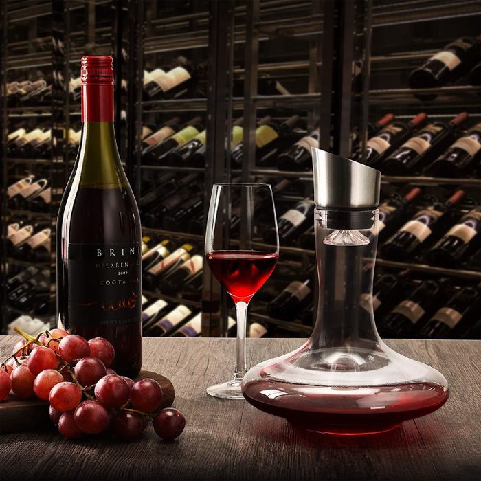 The wine decanter placed next to a bottle of wine and a wine glass