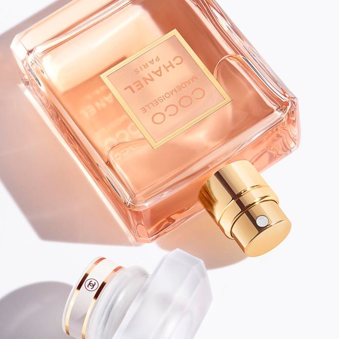 The perfume bottle positioned on its side beside its cap