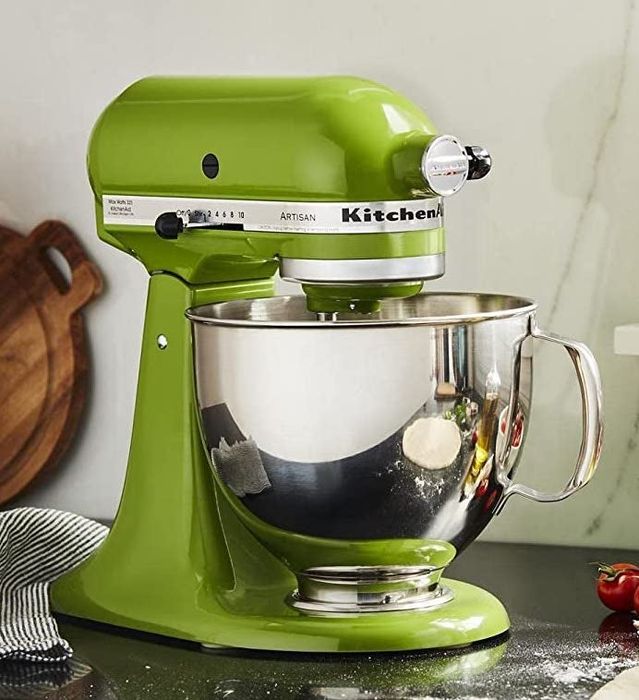 The green stand mixer resting on a kitchen counter.