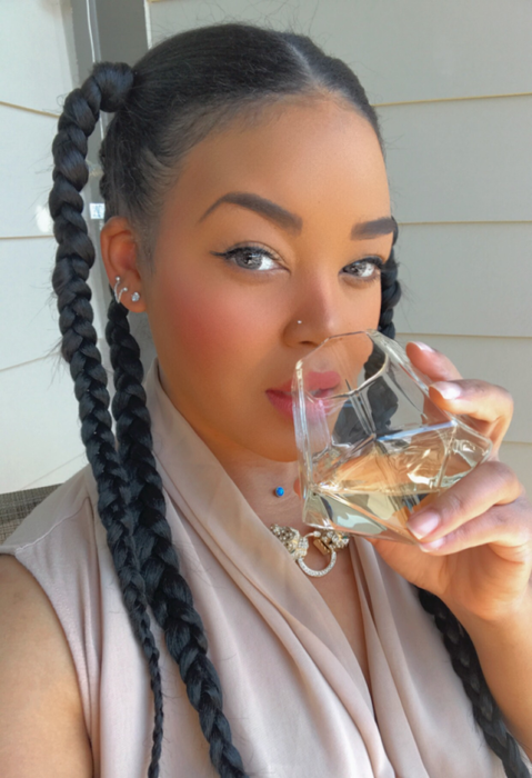 A reviewer sipping whiskey from a diamond-shaped tumbler, showcasing the elegance and unique design of the glass.
