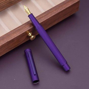 The purple fountain pen resting against a drawer.