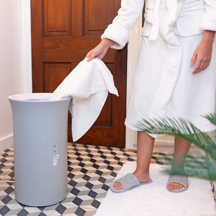 A model removing a towel from the towel warmer.