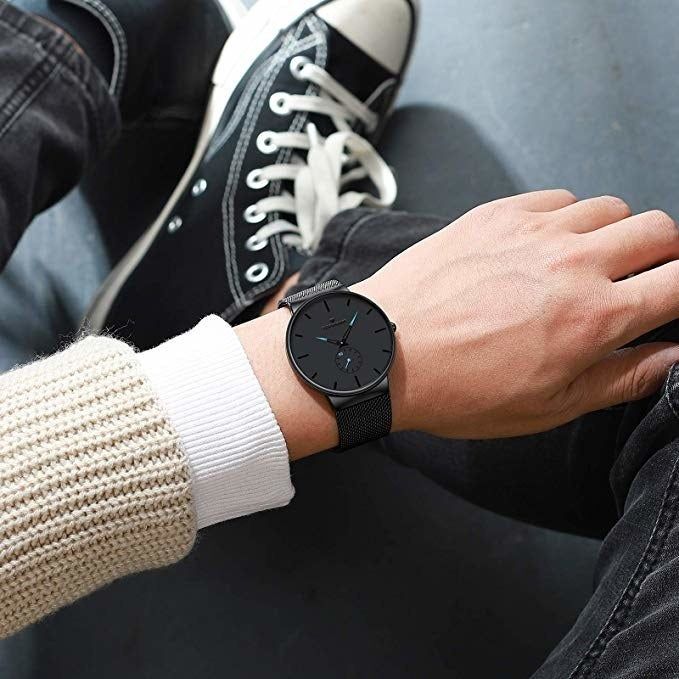 A model wearing the black watch with a matching black wristband.