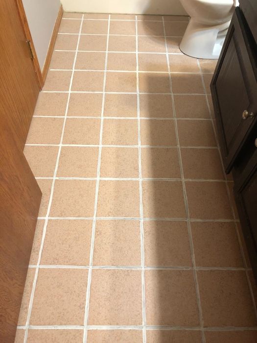 the same bathroom floor, now with pristine white grout throughout the tiles