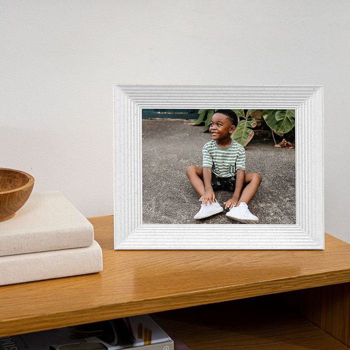 An image of a child displayed in the digital picture frame, which is in the color white.