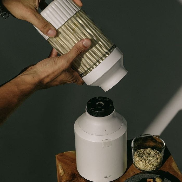 A model easily detaching the white blender cup from its base.