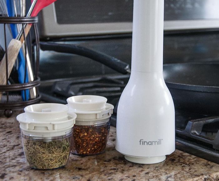 a photo of the white spice grinder with two pods filled with spices