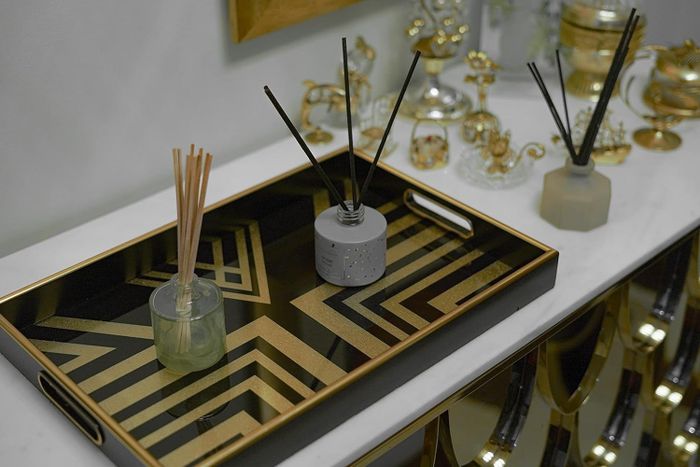 A luxurious black and gold tray adorned with oil diffusers.