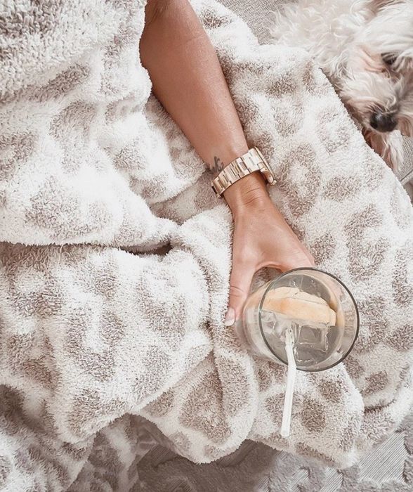 The plush cream-colored blanket with a dark stone leopard print design.