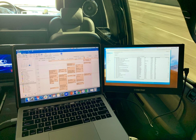 A laptop with a small black monitor attached to its main screen on a desk