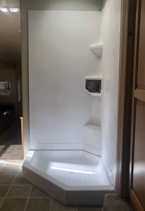 The same shower surround, now bright and white, looking as if it were just installed brand new.