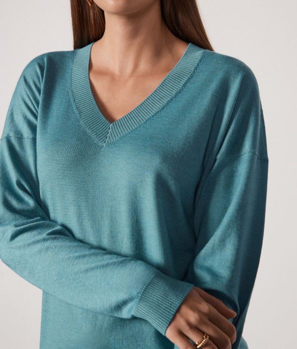 A close-up of the same model, highlighting the intricate fabric details of the sweater.