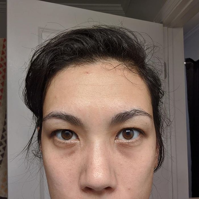 A reviewer displays noticeable dark under-eye bags, highlighting the need for effective concealing.