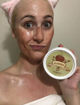 a reviewer applying the face mask and holding the jar up