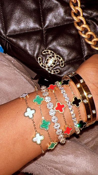 The reviewer is sporting a stack of white, green, and red bracelets.