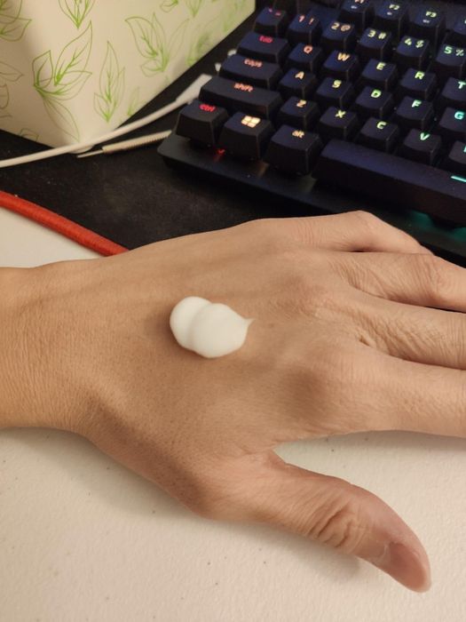 A reviewer applying lotion to their hand
