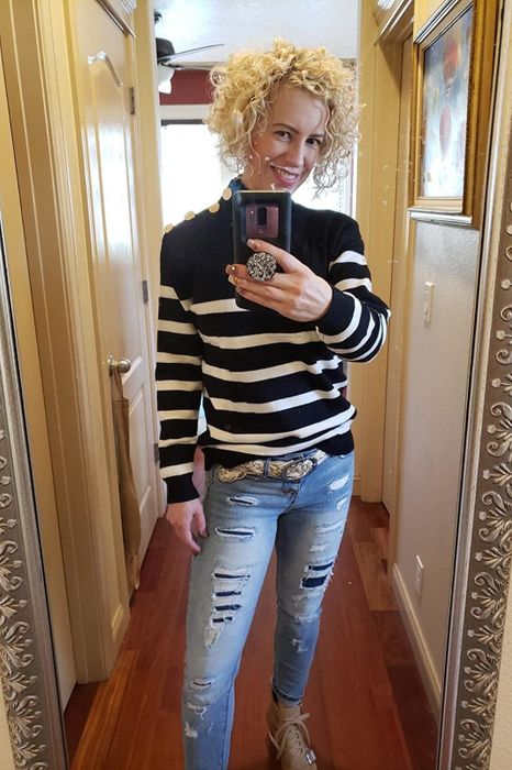 A reviewer is wearing a black and white version of the sweater.