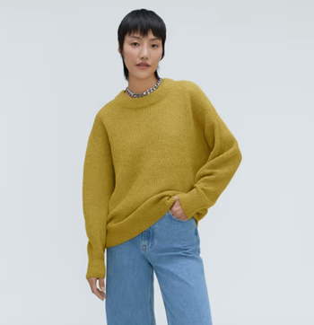 Model wearing a golden palm-colored sweater with jeans
