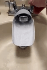 A GIF showing water flowing through a faucet extender attached to a faucet